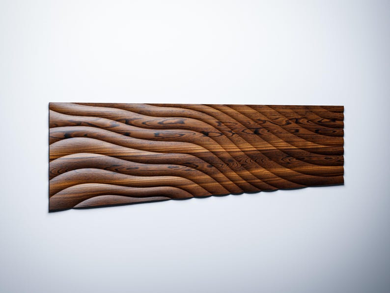 Op de afbeelding: Een lang, rechthoekig houten wandpaneel met een golvende, geribbelde textuur. Het paneel is gemaakt van donkerbruin hout met een natuurlijke houtnerf.