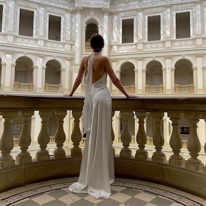 Vestido de novia sencillo con cuello halter en color marfil. Vestido lencero de raso con espalda abierta para recepción. Vestido de novia de verano con cuello halter.