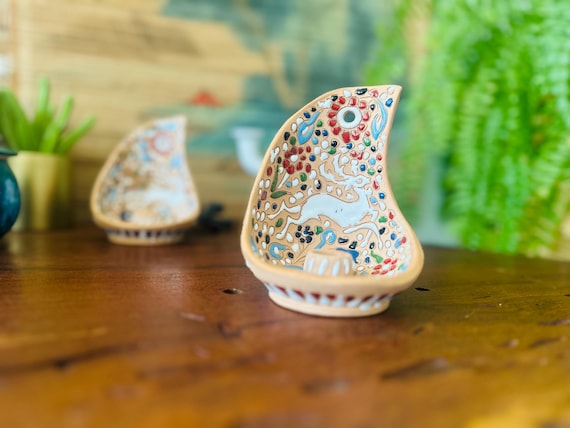 Hand-painted Greek ceramic wall sconce with folk-art deer motifs in bold colors — the kind of one-off piece that anchors a gallery wall instantly.