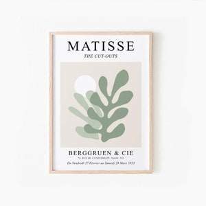 May include: A beige poster with a green abstract leaf design and a white circle. The poster has the text "MATISSE THE CUT-OUTS" at the top and "BERGGRUEN & CIE 79, RUE DE L'UNIVERSITE, PARIS -VII Du Vendredi 27 F&eacute;vrier au Samedi 28 Mars 1953" at the bottom.