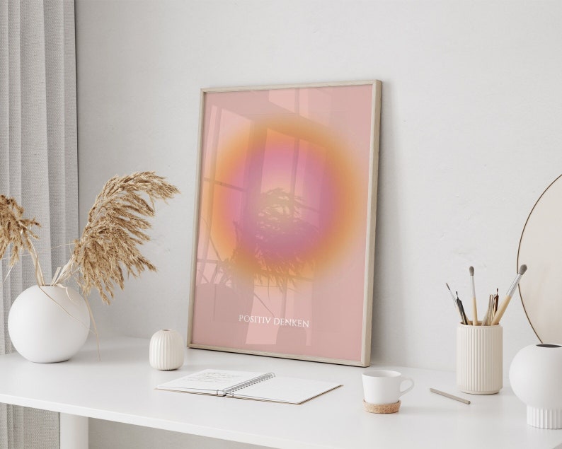 May include: A framed print with a pink and orange gradient circle in the center. The text "POSITIV DENKEN" is at the bottom of the print.