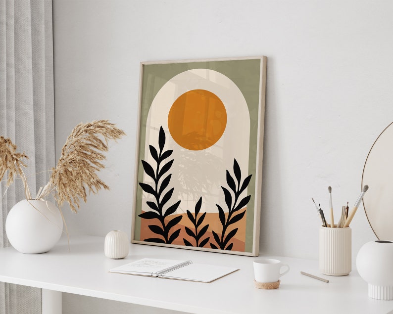 Op de afbeelding: Abstracte kunstprint met een kleurenschema in groen, oranje en bruin. De print bevat een grote oranje cirkel, twee zwarte gestileerde planten en een boogvorm.