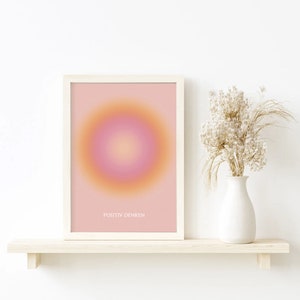 May include: A framed print with a pink and orange gradient circle in the center. The text "POSITIV DENKEN" is printed below the circle.