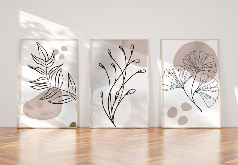 Peut inclure: Trois impressions encadr&eacute;es avec des dessins de lignes abstraites de feuilles et de branches sur un fond blanc avec des formes abstraites rose et brunes en sourdine.