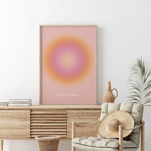 May include: A framed print with a pink and orange gradient circle in the center. The text "POSITIV DENKEN" is printed at the bottom of the print.