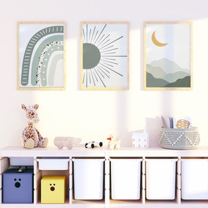 May include: A white shelf unit with six cubbies, two of which are filled with yellow and purple boxes. The other cubbies are empty. There are three framed prints on the wall above the shelf unit, featuring a rainbow, a sun, and a crescent moon. A stuffed giraffe, a toy car, and a toy duck are on the shelf.