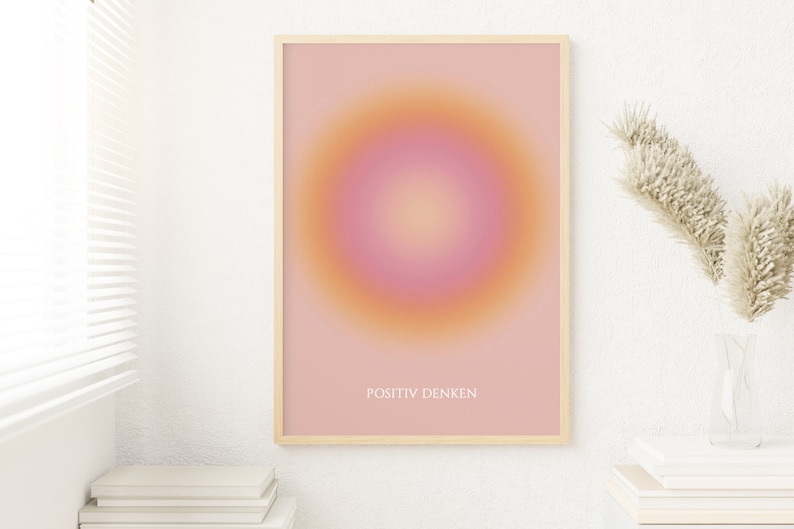 May include: A framed print with a pink and orange gradient circle in the center. The text "POSITIV DENKEN" is printed in white at the bottom of the print.