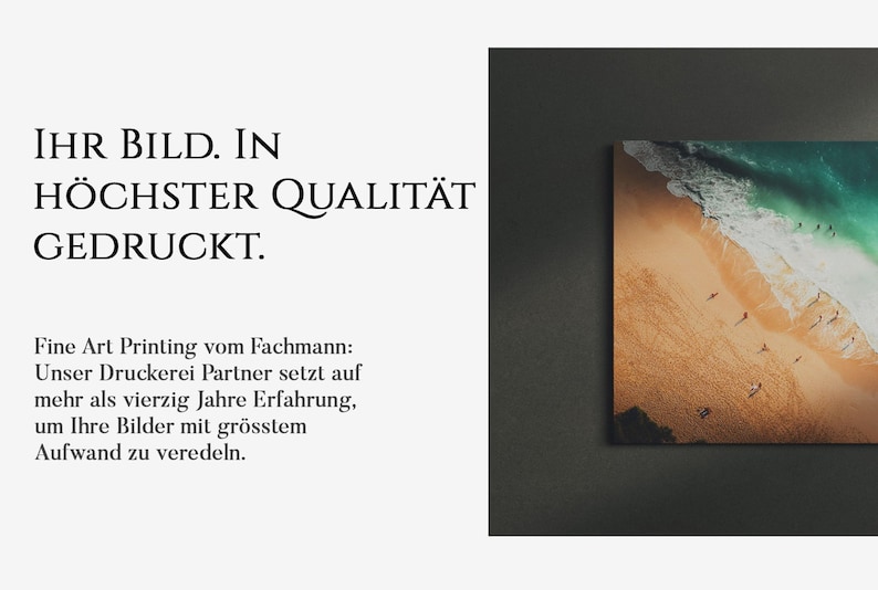 Op de afbeelding: Een ingelijste foto van een strandsc&egrave;ne met turquoise water, witte golven en een zandstrand met mensen die erop lopen. De tekst "IHR BILD. IN H&Ouml;CHSTER QUALIT&Auml;T GEDRUCKT." staat onder de afbeelding.