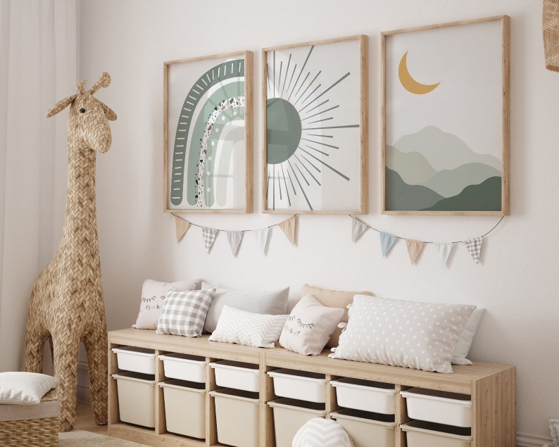 May include: A wooden bench with six storage bins, decorated with three framed prints featuring a rainbow, a sun, and a crescent moon with mountains. The prints have a green, white, and yellow color scheme. The bench is decorated with a string of flags.