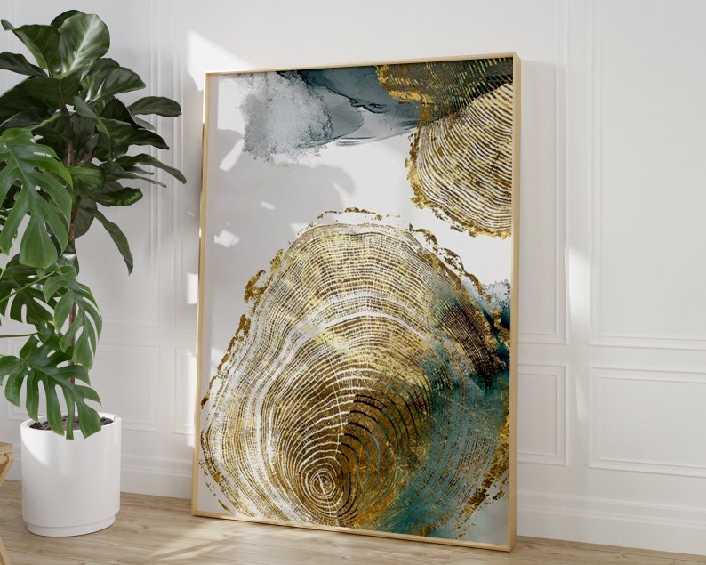 Puede incluir: Impresi&oacute;n de arte de pared abstracto con un esquema de color dorado y verde azulado. La impresi&oacute;n representa un patr&oacute;n de anillos de &aacute;rbol estilizado sobre un fondo blanco.