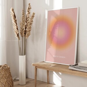 May include: A framed print with a pink and orange gradient circle in the center. The text "POSITIV DENKEN" is printed in white at the bottom of the print.