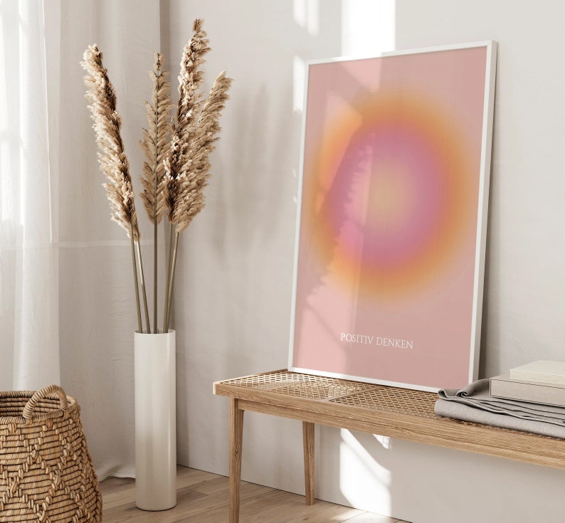 May include: A framed print with a pink and orange gradient circle in the center. The text "POSITIV DENKEN" is printed in white at the bottom of the print.