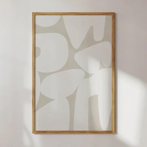 Op de afbeelding: Een ingelijst drukwerk met een abstract ontwerp met witte vormen op een beige achtergrond.