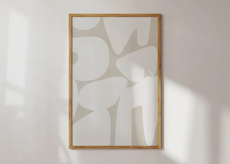 Op de afbeelding: Een ingelijst drukwerk met een abstract ontwerp met witte vormen op een beige achtergrond.