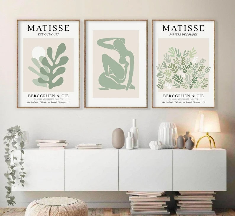 May include: Three framed art prints with a minimalist design featuring green and white abstract shapes. The prints are titled "Matisse The Cut-Outs", "Matisse Papiers Decoupes", and "Berggruen & Cie".