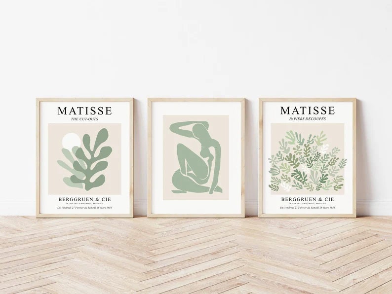 May include: Three framed art prints with a minimalist design featuring green cut-out shapes on a beige background. The prints are titled "Matisse: The Cut-Outs", "Matisse: Papiers Decoupes", and "Matisse: The Cut-Outs".