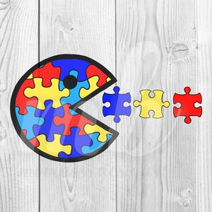 Könnte beinhalten: Ein Pac-Man-förmiges Design aus Puzzle-Teilen in Blau, Gelb und Rot. Der Pac-Man frisst drei Puzzle-Teile in den gleichen Farben.