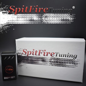 May include: A white box with the text "SpitFireTuning" in red and black lettering on the front. The box is sitting on a black surface. A small black device with the text "SpitFireTuning" is in the foreground.