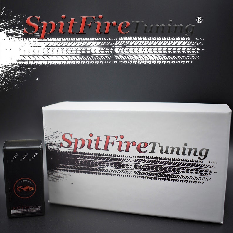 May include: A white box with the text "SpitFireTuning" in red and black lettering on the front. The box is sitting on a black surface. A small black device with the text "SpitFireTuning" is in the foreground.