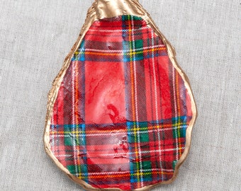 May include: A red, green, and yellow plaid oyster shell dish with a gold rim.