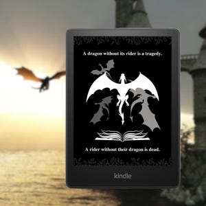May include: A black and white image on a Kindle e-reader. The image shows a white dragon with its wings spread wide. The text reads "A dragon without its rider is a tragedy. A rider without their dragon is dead."