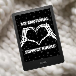 May include: A black and white image on a Kindle e-reader. The image features a pair of skeletal hands forming a heart shape with the text "My Emotional Support Kindle" below.
