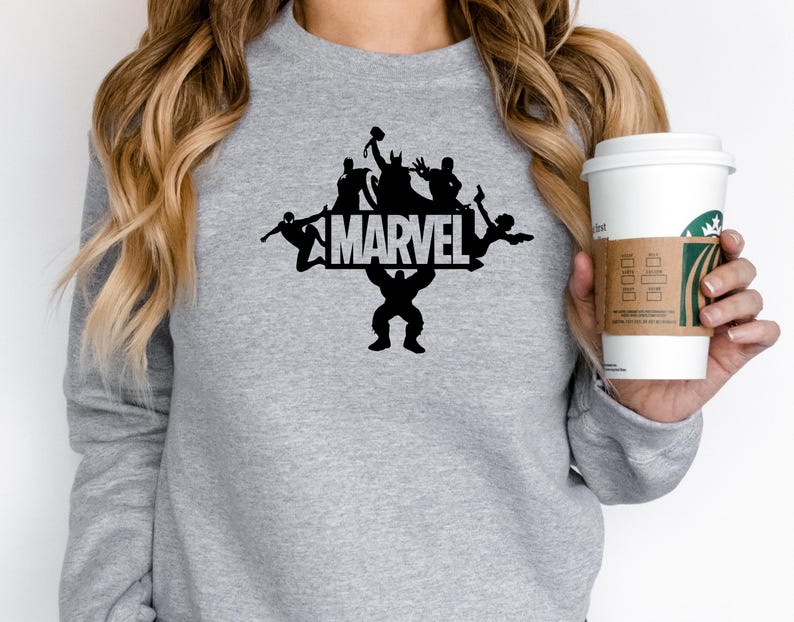 May include: Gray sweatshirt with a black silhouette of Marvel characters, including Hulk, Thor, Iron Man, and Spider-Man, with the word "MARVEL" in white letters.