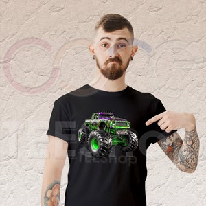 May include: A black t-shirt with a green and purple monster truck graphic. The truck has large tires and is driving on a dirt track. The t-shirt is a great gift for monster truck fans.