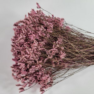May include: A bunch of dried pink flowers with long, thin stems. The flowers are small and delicate, and they have a soft, feathery texture.
