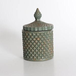 May include: A green ceramic jar with a diamond pattern and a lid with a pointed top.
