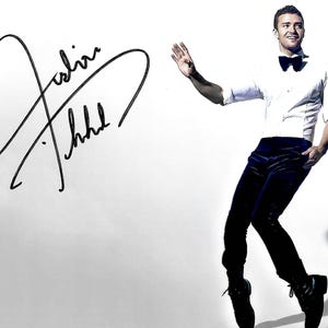May include: An image featuring a person in a white dress shirt, black bow tie, and dark blue pants. The person is striking a pose with one arm raised. The image also includes a black signature on the left side.