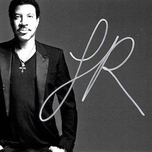 Può includere: Ritratto in bianco e nero di un uomo in abito nero, camicia nera e ciondolo a croce. L'immagine include una firma bianca sul lato destro. Lo sfondo è grigio.