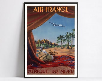 Può includere: Un poster vintage di viaggio per Air France che mostra un uomo seduto su un tappeto rosso davanti a una tenda, con un aereo che vola sopra. Il poster recita "Air France Afrique du Nord".