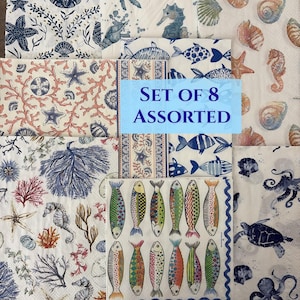 May include: Set of 8 assorted decorative paper napkins with various sea-themed designs. The napkins feature illustrations of starfish, seahorses, fish, coral, and seashells in shades of blue, coral, and white.
