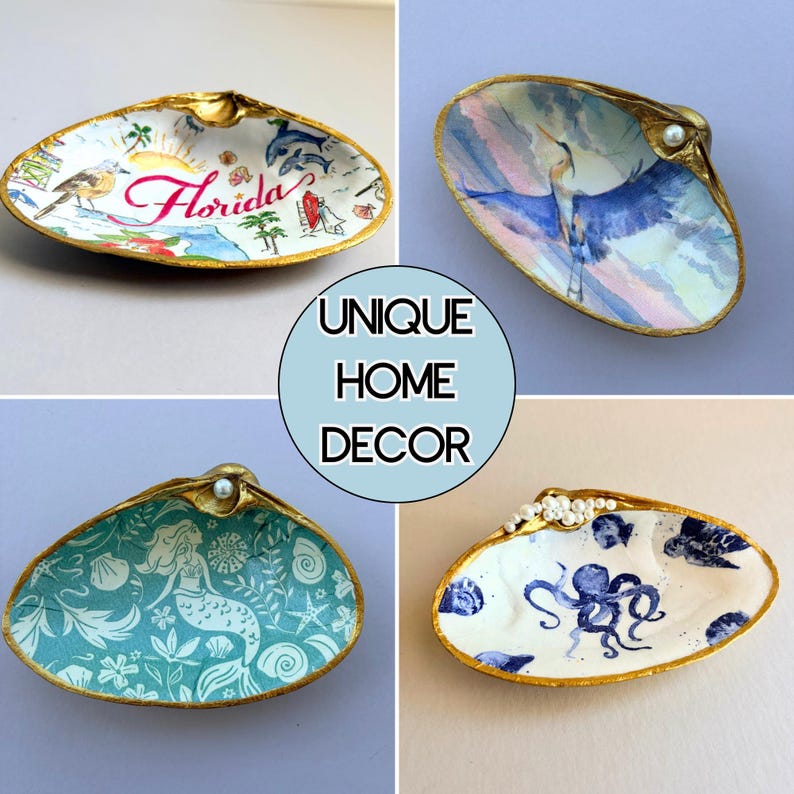 Puede incluir: Cuatro conchas decorativas con bordes pintados en oro. Una muestra un mapa de Florida con un ave y delfines, otra una garza azul, una tiene un patr&oacute;n de sirena turquesa y la &uacute;ltima un pulpo azul y vida marina. Cada concha tiene una perla.