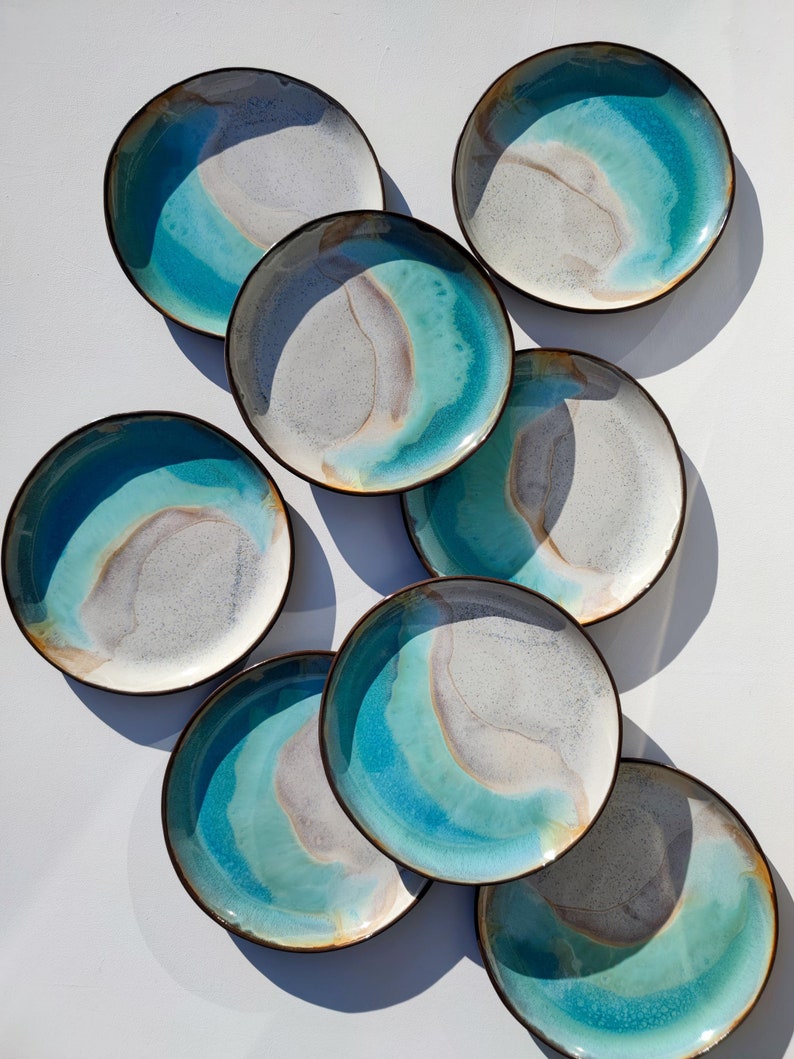 K&ouml;nnte beinhalten: Satz von acht Keramiktellern mit einer blauen, wei&szlig;en und braunen Glasur. Die Teller haben ein einzigartiges, marmoriertes Design.