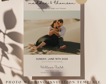 May include: A photo wedding invitation template with the names "maddie & thomson" in a script font. The invitation includes a photo of a couple embracing in a desert setting. The date and time of the wedding are also included.