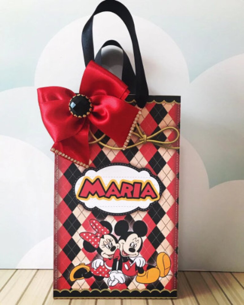 Peut inclure: Sac cadeau rouge et noir avec un n&oelig;ud rouge et une poign&eacute;e noire. Le sac a un motif &agrave; carreaux et repr&eacute;sente Mickey et Minnie Mouse. Le sac est personnalis&eacute; avec le nom "Maria".