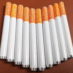 May include: Ten white metal tubes with orange and white stripes. The tubes are about 10 inches long and have a rounded end.