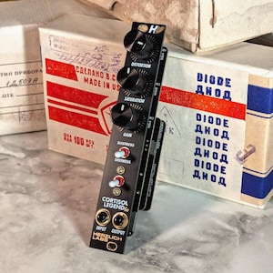 May include: A black and gold effects pedal with the text "CORTISOL LEGEND Ge" and "HERZLICH LABS". The pedal has knobs labelled "DISTORTION", "SATURATION", "GAIN", "EUSTRESS", and "DISTRESS".
