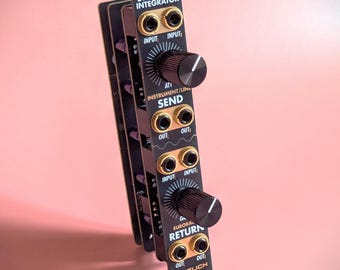 May include: Black modular synthesizer module with gold input and output jacks and black knobs. The module has the text "STEREO FX INTEGRATOR", "ATI INSTRUMENT/LIN SEND", "GA EURORA RETURN", and "HERZLICH LABS". The background is a solid pink colour.