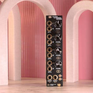 May include: Black Quad Stereo Mixer with multiple input and output jacks, volume knobs, and the text "QUAD STEREO MIXER". The mixer has a sleek design with a black faceplate and silver accents. The brand name "HERZLICH LABS" is printed at the bottom.