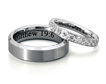May include: Two silver wedding bands. The wider band has the inscription "Matthew 19:6". The narrower band has a row of small diamonds.