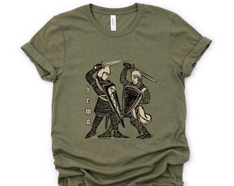 May include: A green t-shirt with a black and white illustration of two knights fighting with swords. The text "HEcMA" is printed on the shirt.