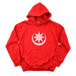 May include: A red hooded sweatshirt with a white graphic design on the front. The design features a starburst within a crescent shape. The sweatshirt has a kangaroo pocket and a drawstring hood.