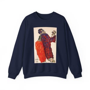 Könnte beinhalten: Ein marineblaues Sweatshirt mit Rundhalsausschnitt und einem rechteckigen Grafikdruck auf der Brust. Der Druck zeigt ein expressionistisches Gemälde zweier Figuren in dunkelroter und leuchtend oranger Kleidung mit sichtbaren Pinselstrichen.