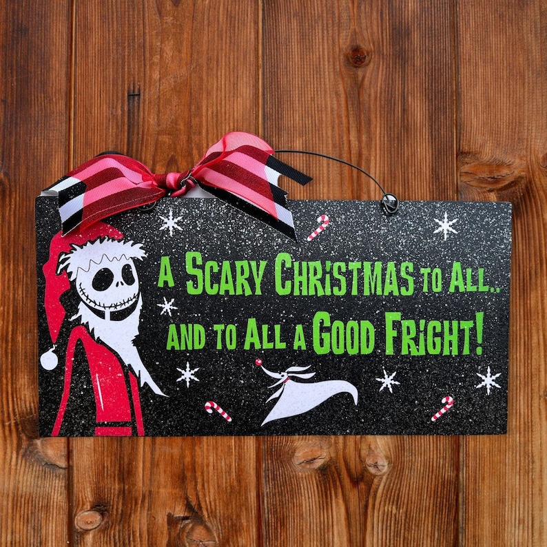 May include: A black wooden sign with glitter and a white border. The sign features a cartoon image of Jack Skellington dressed as Santa Claus. The text on the sign reads "A Scary Christmas to All... And to All a Good Fright!"