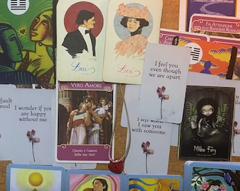 Può includere: Uno spargimento di carte dei tarocchi con illustrazioni e testo colorati. Le carte includono "Lui", "Bei", "Ti sento anche se siamo separati", "Ti ho visto con qualcuno", "Questo è l'amore della tua vita!" e "Milaw Fairy".