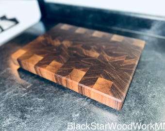 May include: A large, rectangular cutting board made of dark wood with a checkered pattern. The board is made of walnut and has a natural finish.