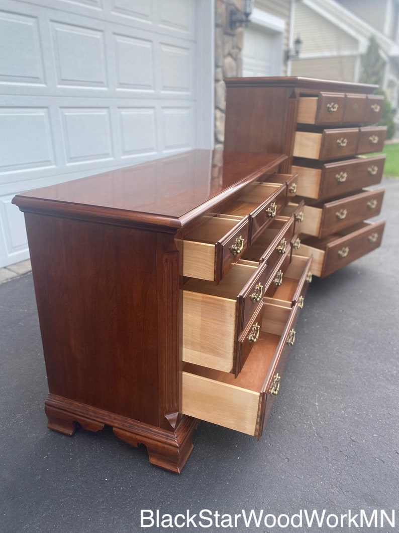 Puede incluir: Un conjunto de dos c&oacute;modas de madera con varios cajones. Las c&oacute;modas son de un rico color caoba y tienen herrajes de lat&oacute;n. Los cajones est&aacute;n abiertos, revelando el interior de madera clara.